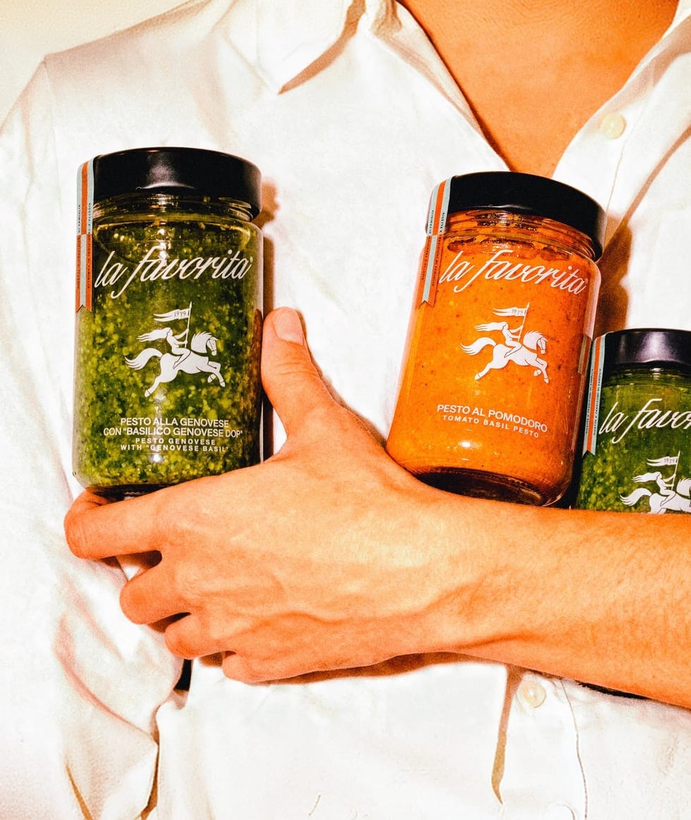 Vasetti di pesto e sugo La Favorita tenuti in mano