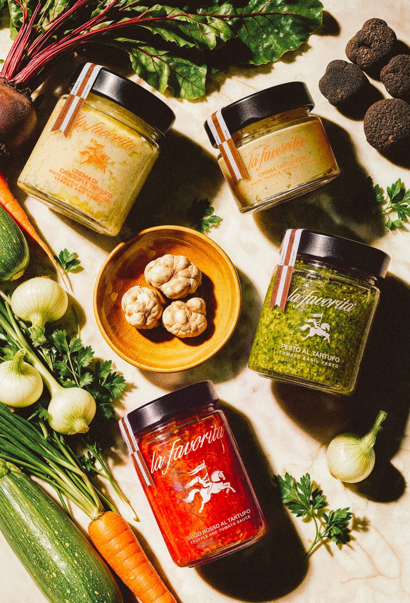 Vasetti La Favorita visti dall'alto tra tartufi, aglio, cipollotti, zucchine e carote